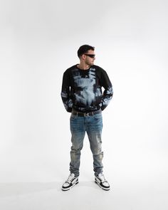 a man standing in front of a white background wearing black and grey tie - dye shirt