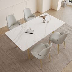 an aerial view of a dining room table with chairs and a vase on the floor