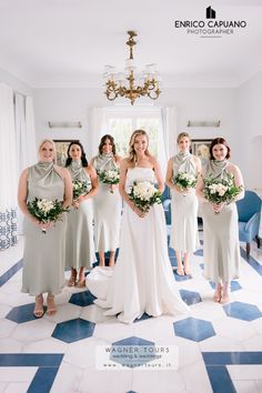 a group of women standing next to each other in front of a blue and white floor