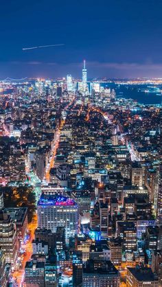 an aerial view of new york city at night with the empire building in the distance