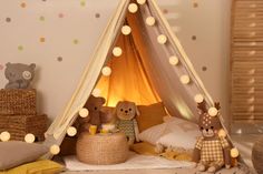 a child's teepee with stuffed animals and lights on the wall behind it