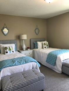 two beds in a bedroom with blue and white bedding