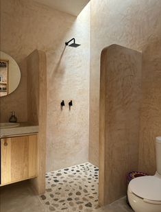 a bathroom with a toilet, sink and shower in it's center wall that is made out of plywood