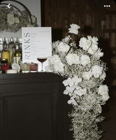 white flowers and wine are on the bar