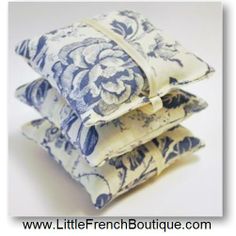 three blue and white pillows stacked on top of each other in the shape of flowers