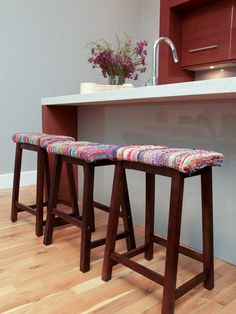 two wooden stools sitting in front of a counter