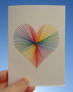 a heart made out of colored sticks in the shape of a rainbow