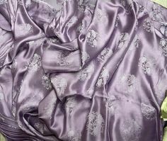 a purple blanket laying on top of a bed