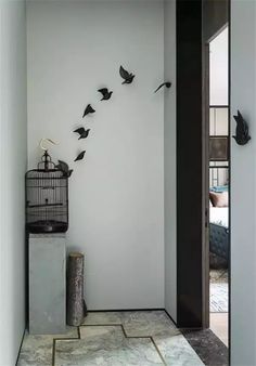 a birdcage is hanging on the wall next to a door with birds in it