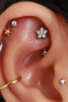 an ear with three different types of piercings on it's side, and one is