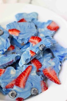 strawberries and blueberry ice cream on a white plate with red, white and blue icing