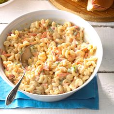 a white bowl filled with macaroni and cheese on top of a blue napkin