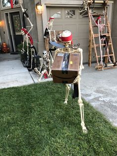 skeleton statues in front of a house decorated for halloween