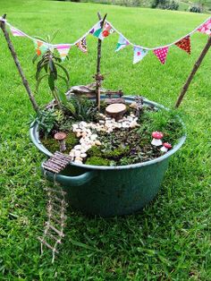 a potted planter filled with lots of plants and rocks in the middle of grass