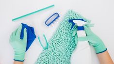 a person with gloves and cleaning supplies on top of a white surface next to a green mop