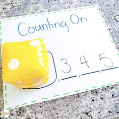 a counting game with a piece of yellow paper sitting on the ground next to it