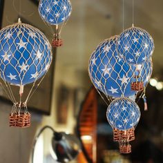 three blue and white hot air balloons hanging from strings