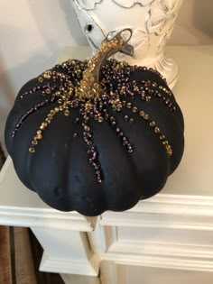 a black pumpkin sitting on top of a white table