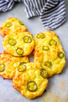 four cheesy pizzas with jalapenos on top