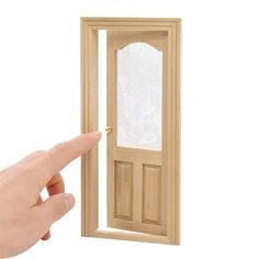 a hand is pointing at an open door with a window on the inside and outside