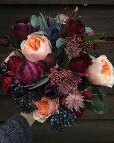 a person holding a bouquet of flowers in their hand