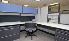 an office cubicle with black and gray drawers