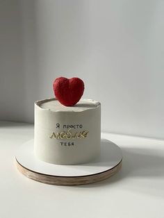 a white cake with a red heart on top