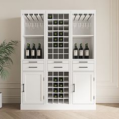 a white cabinet filled with lots of bottles and glasses next to a potted plant