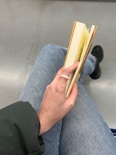 a person sitting on the ground reading a book