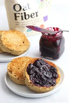 two white plates topped with blueberry jam next to a bottle of oat fiber