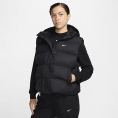 Up your outerwear game in this puffer vest. A loose fit makes it ideal for layering while the Nike Therma-FIT technology helps manage your body’s natural heat to help keep you warm in cold-weather conditions. A water-repellent finish, bungees at the hem and a hood work together to help shield you from wind and rain. Sporty Hooded Vest For Outdoor Activities, Functional Puffer Jacket For Cold Weather, Nike Winter Gym Outerwear, Functional Hooded Nike Puffer Jacket, Puffer Outerwear For Winter Sports In Athleisure Style, Athleisure Puffer Outerwear For Winter Sports, Functional Black Puffer Jacket For Outdoor Activities, Black Functional Puffer Jacket For Outdoor Activities, Black Sporty Puffer Vest