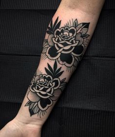 a black and white flower tattoo on the arm