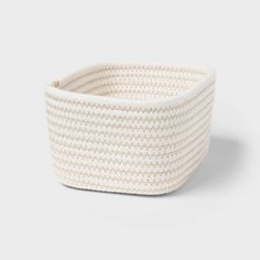 a white woven basket on a grey background, with the lid open to show it's interior