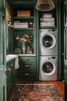 a washer and dryer in a small room with green painted walls, wood flooring and rug