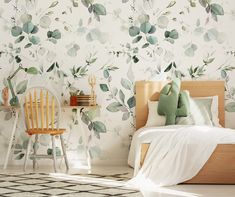 a bed room with a neatly made bed next to a wallpapered wall and a chair