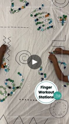 two children are drawing letters on a sheet with bead work in the shape of numbers