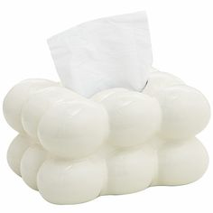 a white tissue dispenser sitting on top of a pile of balls with a napkin in it