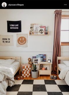 a bedroom with two beds, a checkered floor and pictures on the wall above them