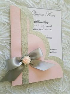 a pink and silver wedding card with a bow