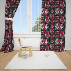 a living room with a spiderman curtain and chair in front of the window,