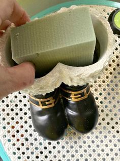 a pair of black shoes sitting on top of a table next to a green sponge