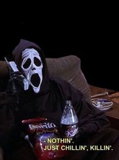 a person wearing a mask sitting on a couch with two sodas in front of them