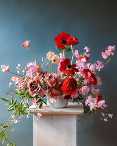 a vase filled with lots of different colored flowers