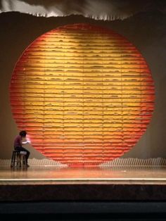 a person sitting on a chair in front of a large object