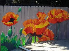 an image of painted flowers on the side of a fence