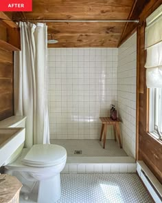 a white toilet sitting in a bathroom next to a sink and shower stall with wooden ceiling