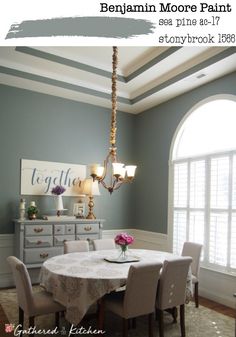 the dining room is painted in blue and white with an oval table surrounded by chairs