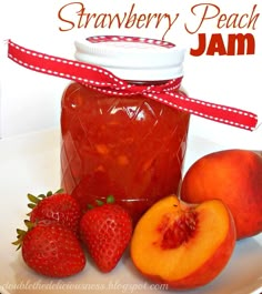 a jar of peach jam next to some fruit on a plate with a red ribbon