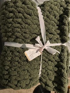 a pile of green towels wrapped in white ribbon