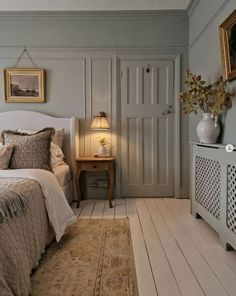 a white bed sitting in a bedroom next to a dresser